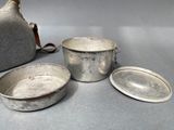 three pots and a jug sitting on a table