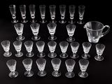 a lot of glasses and a pitcher on the table