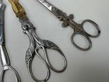 three pairs of scissors sitting on a table next to each other