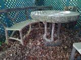 a table and two chairs in the middle of a pile of leaves
