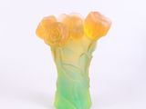 un vase contenant des fleurs, posé sur une surface blanche