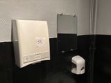 des toilettes avec un distributeur de papier dans un coin