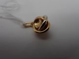 a gold pendant with a knot on it on a white surface