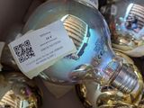 many christmas ornaments in a box with a price tag