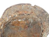 a rusted metal bowl sitting on a white surface