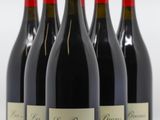 six bouteilles de vin rouge sont alignées sur une surface blanche