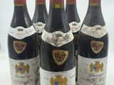 six bouteilles de vin sont alignées sur une surface blanche