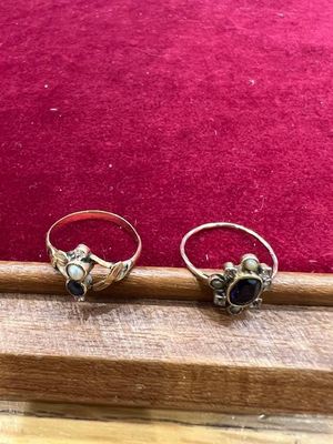 deux bagues ornées de pierres bleues, posées sur une table en bois