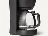 a black coffee maker sitting on top of a white counter