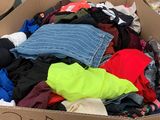 une boîte en carton remplie de vêtements, posée sur une table