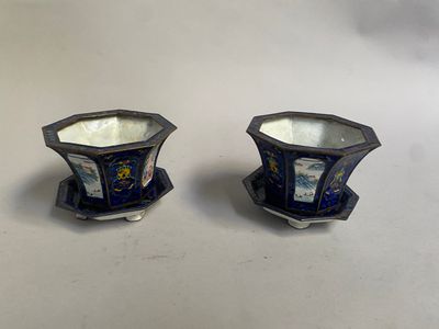 une paire de vases bleus et blancs posés sur une surface blanche