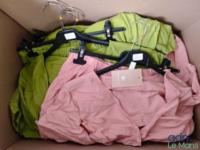 trois paires de pantalons dans une boîte avec des cintres