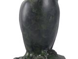 statue of an owl sitting on a rock on a white background