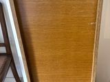 une armoire en bois avec une porte et une chaise à côté