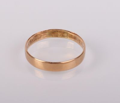 gros plan d'une bague en or sur une surface blanche