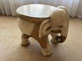 a small wooden elephant that is sitting on the floor
