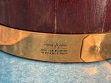 a close up of a brass plate on a wooden drum