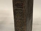 an old book sitting on top of a table next to a white wall