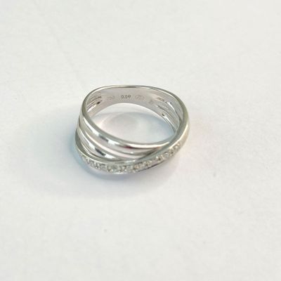 une bague en argent posée sur une surface blanche