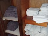 many folded towels on a shelf in a closet