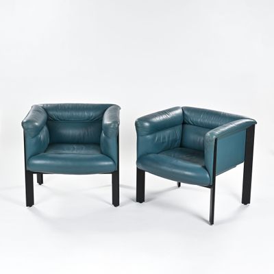 une paire de fauteuils en cuir bleu aux pieds noirs, sur fond blanc