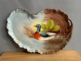 a bird sitting on top of a decorative shell