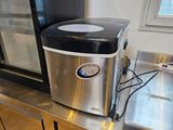 une petite machine à glaçons posée sur un plan de travail dans une cuisine