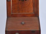 a small wooden desk with a clock on top of it
