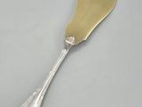 a silver spoon with a gold handle on a white surface