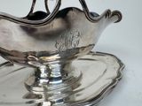 a silver plate with a silver bowl on top of it