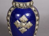 a blue vase with a gold decoration on it