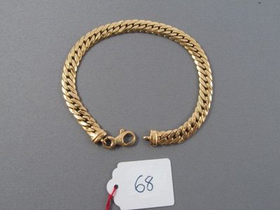 une photo d'un bracelet en or auquel est attachée une étiquette