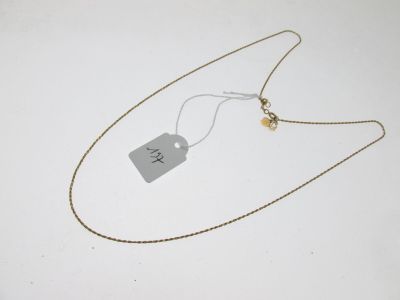 une photo d'un collier muni d'une étiquette, posé sur une surface blanche