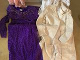three dresses are laid out on the floor next to a heater