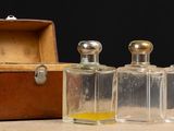 trois flacons de parfum posés à côté d'une boîte en bois