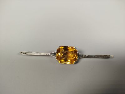 un gros plan d'un bijou orné d'une pierre jaune