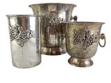 three silver vases with pinecones on them sitting next to each other