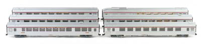 two model trains sitting side by side on a white surface