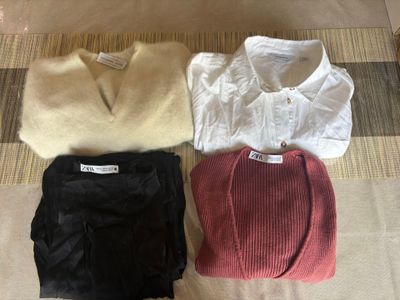 three pairs of sweaters and pants are laid out on the floor