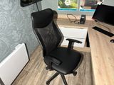 a black office chair sitting in front of a computer desk
