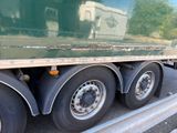 a green semi truck that is parked on the side of the road