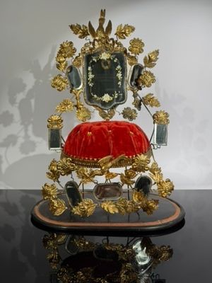 a gold and red chair with a red cushion on it
