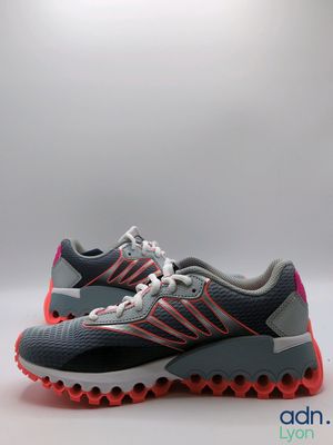 a pair of grey and pink running shoes on a white background
