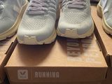several pairs of running shoes are on a box in a store
