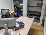 a desk with a computer monitor and a printer on it