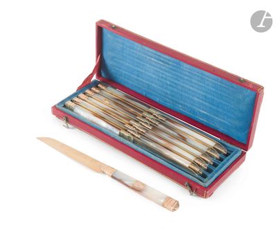un étui rouge contenant un lot de six stylos et un couteau