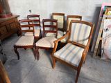six chaises et une commode dans une pièce