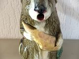 un ours en céramique qui tient une banane dans la gueule