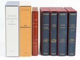 trois livres posés l'un à côté de l'autre sur une surface blanche