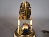 a clock that has a globe on top of it
